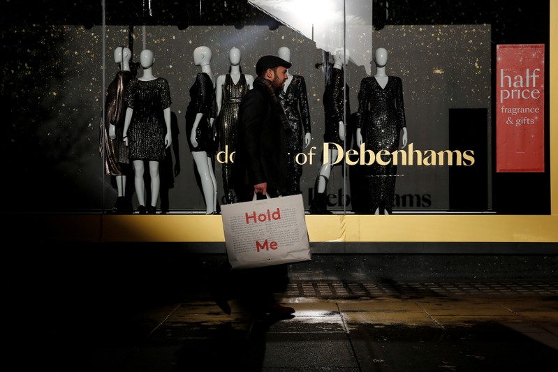 FILE PHOTO: Shoppers walk past a window display at the Debenhams department store on Oxford Street in London