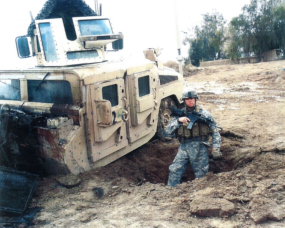 Sgt. Travis Atkins stands next to his vehicle after it was damaged by an improvised explosive devise in Iraq during 2007.