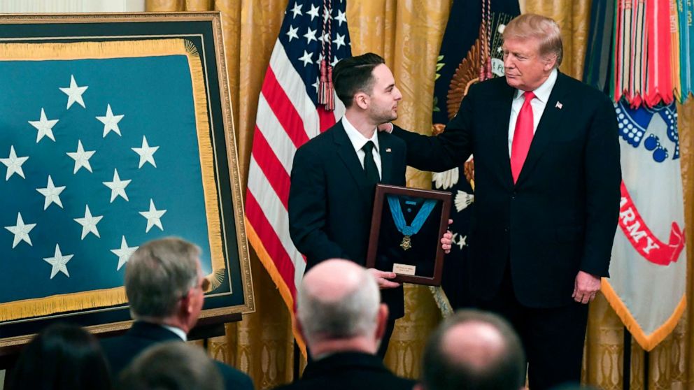 President Donald Trump presents a posthumous Medal of Honor for Army Staff Sergeant Travis Atkins, to his surviving son Trevor Oliver, during a ceremony in the East Room of the White House in Washington, DC, March 27, 2019.