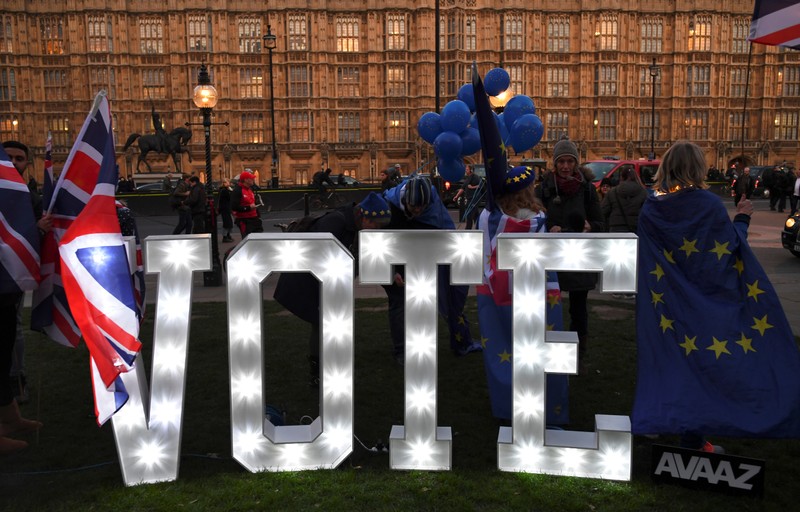Anti-Brexit protesters stand outside the Houses of Parliament in London