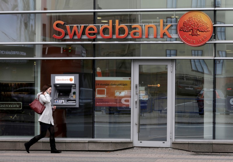 FILE PHOTO: A woman walks past Swedbank branch in Riga