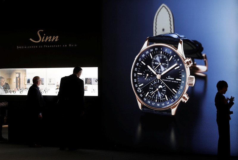 Visitors stand in front of the exhibition stand of German watch manufacturer Sinn at the Baselworld watch and jewellery fair in Basel
