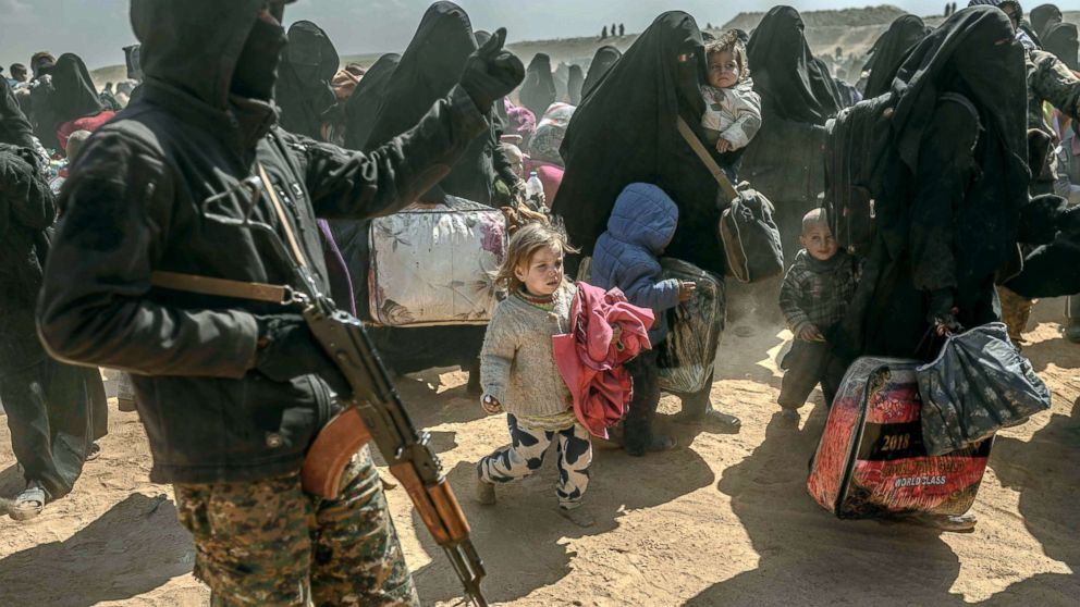 Women and children, evacuated from the Islamic State group's embattled holdout of Baghouz, arrive at a screening area held by the US-backed Kurdish-led Syrian Democratic Forces in Deir Ezzor, Syria, March 6, 2019. Veiled women carrying babies and wounded men on crutches hobbled out of the jihadist village after US-backed forces pummeled the besieged enclave.