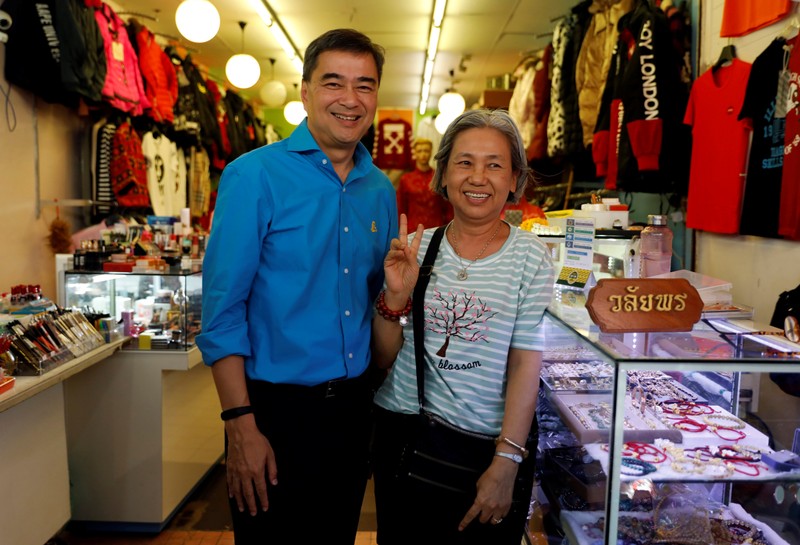 Democrat Party leader and former Thailand's Prime Minister Abhisit Vejjajiva poses with a supporter during his campaign rally in Bangkok