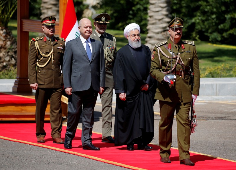 Iraq's President Barham Salih walks with Iranian President Hassan Rouhani during a welcome ceremony at Salam Palace in Baghdad