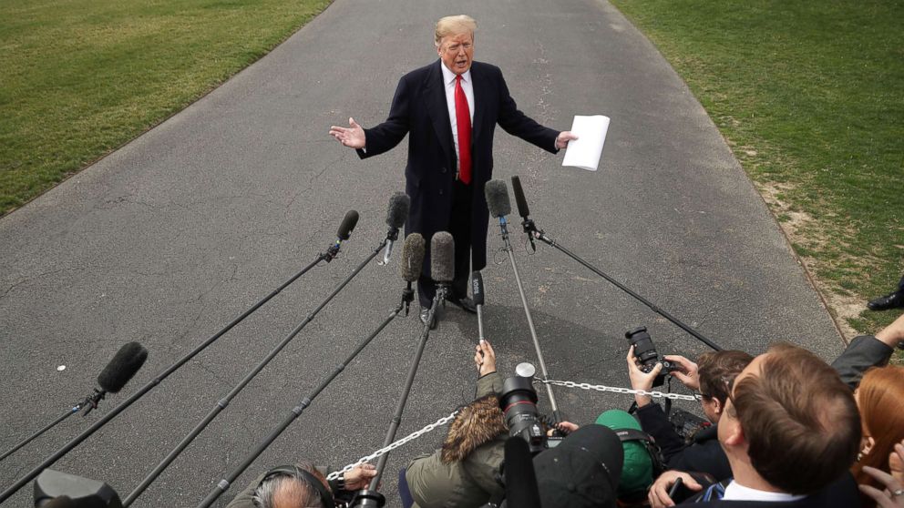 President Donald Trump talks with journalists before departing the White House March 20, 2019.