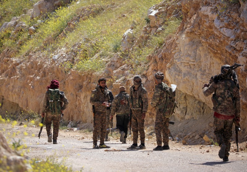 FILE PHOTO: Fighters from SDF stand together in the village of Baghouz, Deir Al Zor province