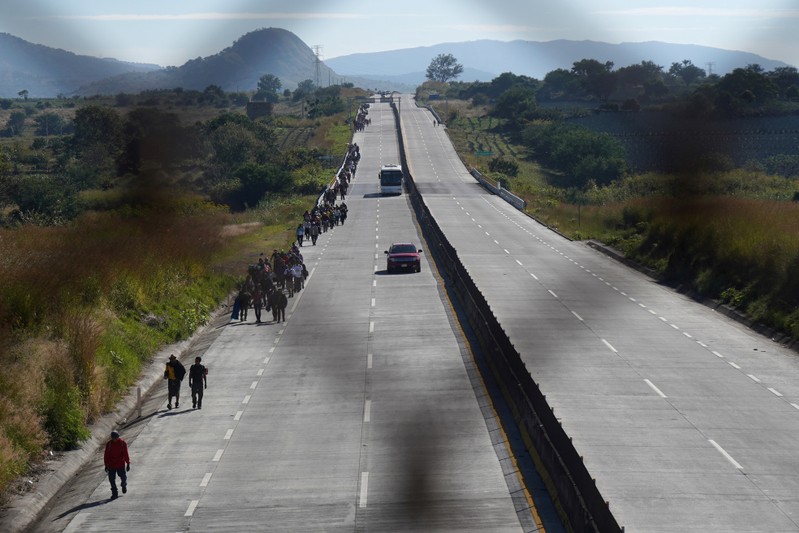 FILE PHOTO: A migrant, part of a caravan of thousands traveling from Central America en route to the United States, walk on the motorway on the outskirts of Guadalajara