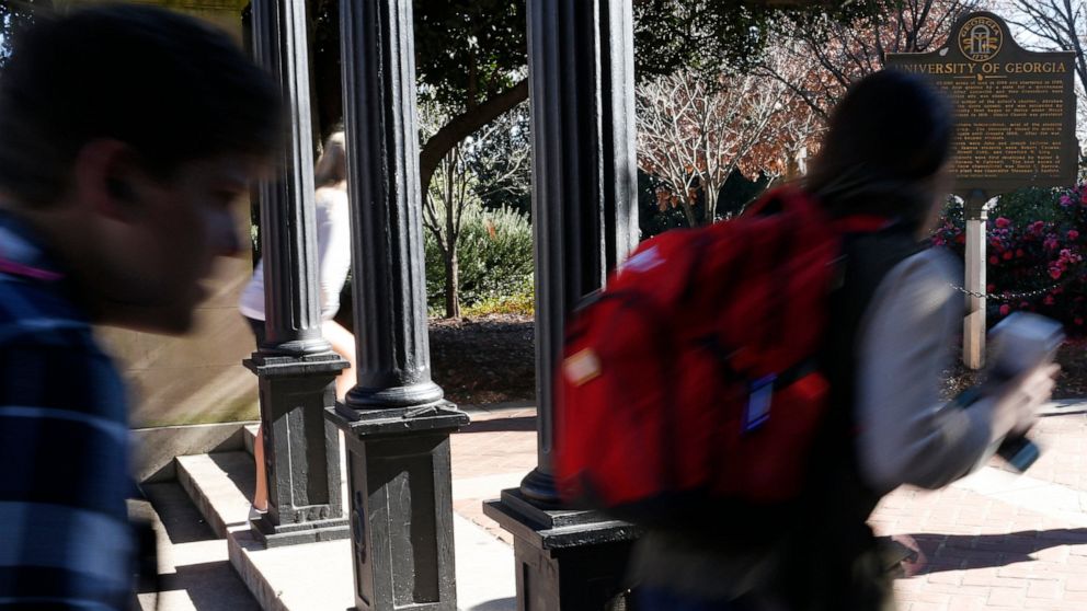 In this Jan. 9, 2019, file photo University of Georgia undergraduate students avoid walking under the university arch on the first day of the spring semester in Athens, Ga.