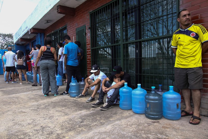 People queue to try to buy potable water during a blackout in Puerto Ordaz