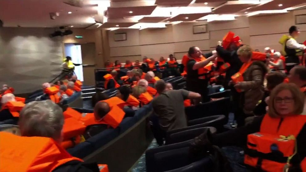This image grab from a handout video made available to AFTV, March 24, 2019, by a passenger onboard the cruise ship Viking Sky shows fellow passengers gathering in a room with life jackets after the cruise ship ran into trouble in rough seas off the Norwegian coast.
