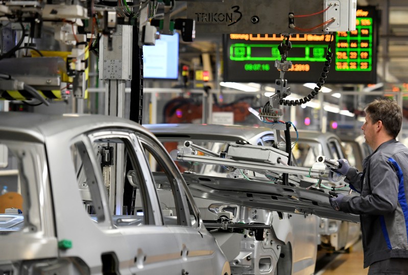 FILE PHOTO: An employee moves car components in a production line at the Volkswagen plant in Wolfsburg