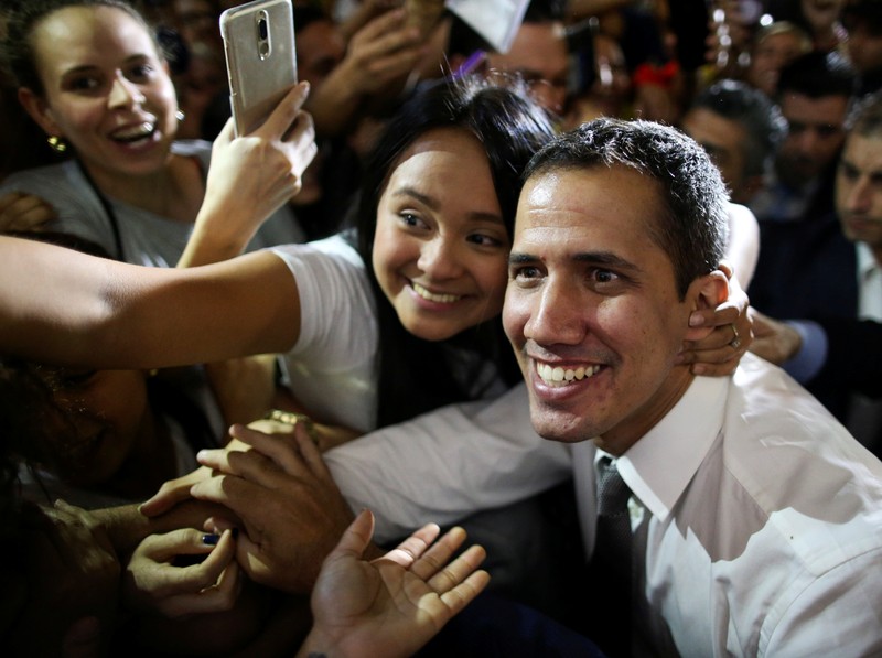 Venezuelan opposition leader Juan Guaido, who many nations have recognized as the country's rightful interim ruler, salutes to Venezuelan citizens living in Argentina after giving a news conference at the San Martin Palace in Buenos Aires