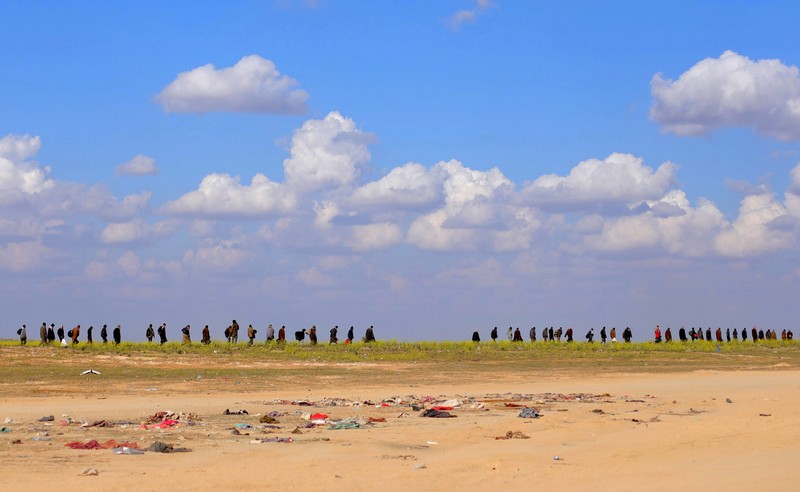 Civilians walk together near Baghouz, Deir Al Zor province