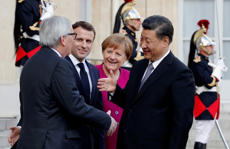 French President Emmanuel Macron, German Chancellor Angela Merkel and European Commission President Jean-Claude Juncker welcome Chinese President Xi Jinping at the Elysee Palace in Paris