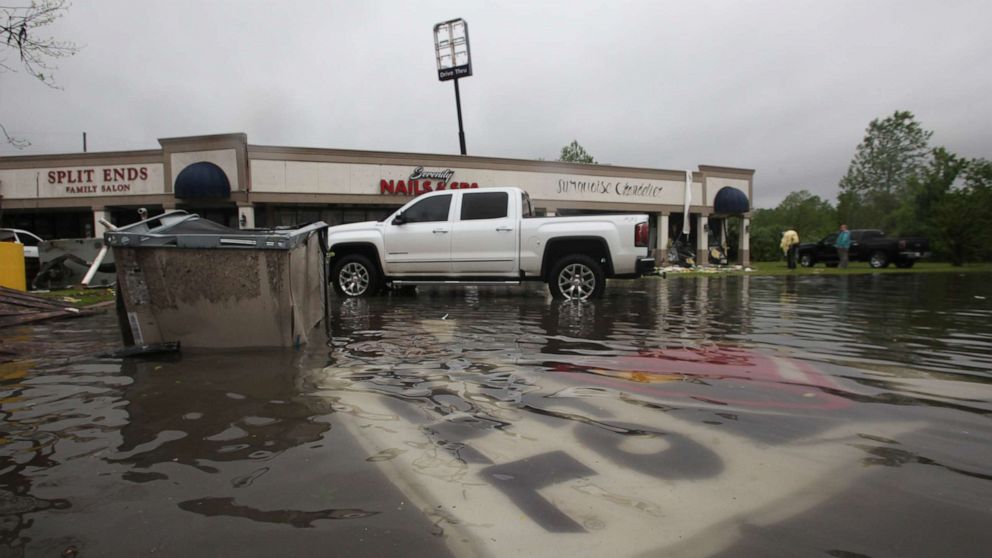 Debris is strewn in flooded water in the Pemberton Quarters strip mall following severe weather, April 13, 2019, in Vicksburg, Miss.