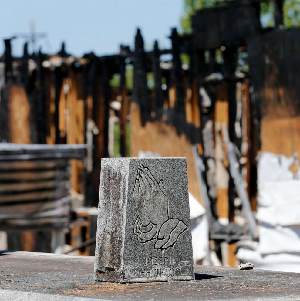 Graves from a cemetery are seen behind the burnt ruins of the Greater Union Baptist Church, one of three that recently burned down in St. Landry Parish, are seen in Opelousas, La., April 10, 2019.