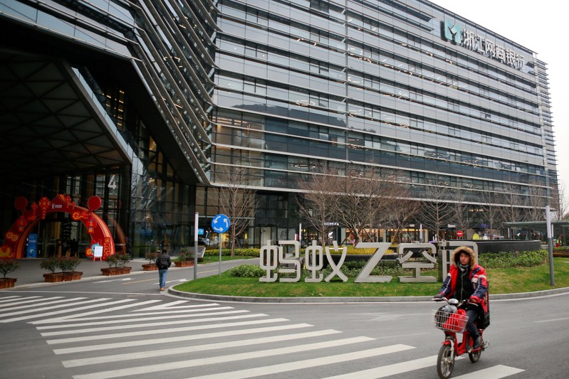 FILE PHOTO: Man cycles past MYbank logo in Hangzhou