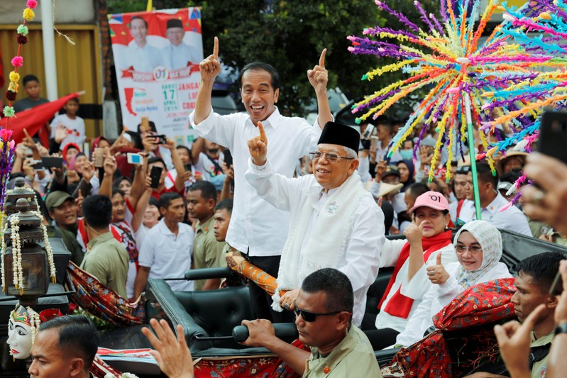 FILE PHOTO: Indonesia's President and presidential candidate for the next election Joko Widodo and his running mate for the upcoming election Ma'ruf Amin gesture as they greet their supporters at a carnival during campaign rally in Tangerang