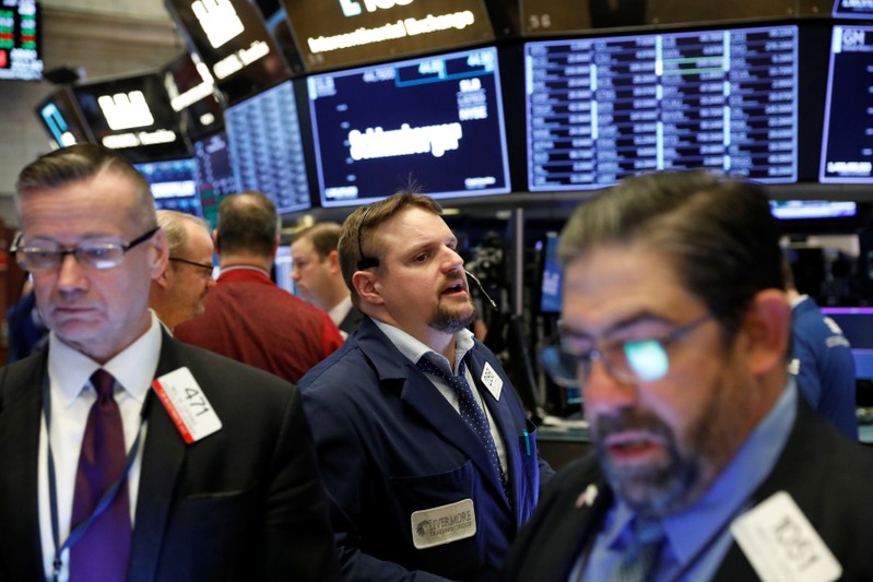 FILE PHOTO: Traders work on the floor of the New York Stock Exchange shortly after the opening bell in New York