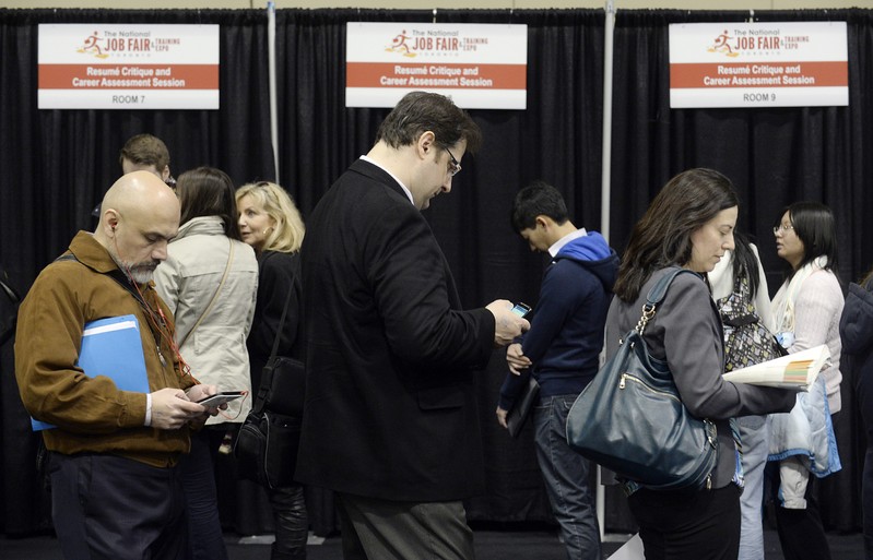 FILE PHOTO: People wait in line for resume critique and career assessment sessions at the 2014 Spring National Job Fair and Training Expo in Toronto