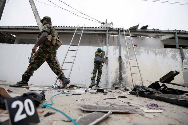 Security personnel seen at the site of an overnight gun battle between troops and suspected Islamist militants, on the east coast of Sri Lanka, in Kalmunai