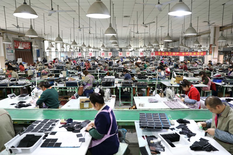 Employees work on the production line of a factory manufacturing fashion accessories in Sihong