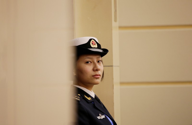 A female soldier of the PLA Navy stand stands guard at a news conference in Qingdao