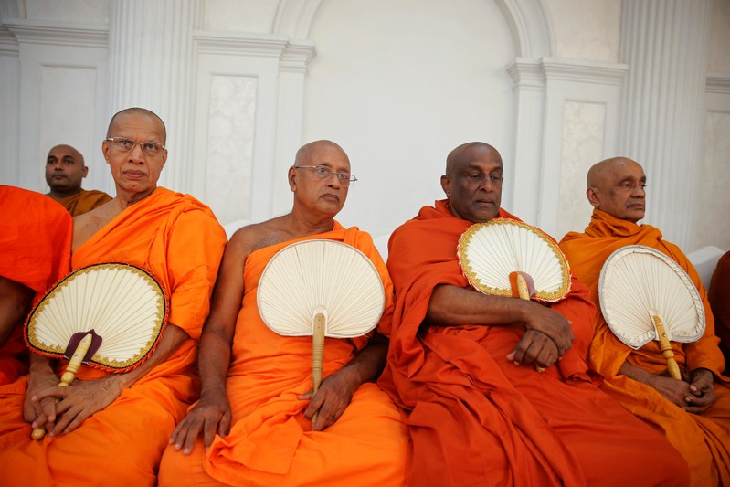 Monks take part in a Buddhist ceremony as a tribute to victims, a week after a string of suicide bomb attacks across the island on Easter Sunday, at Kingsbury Hotel in Colombo