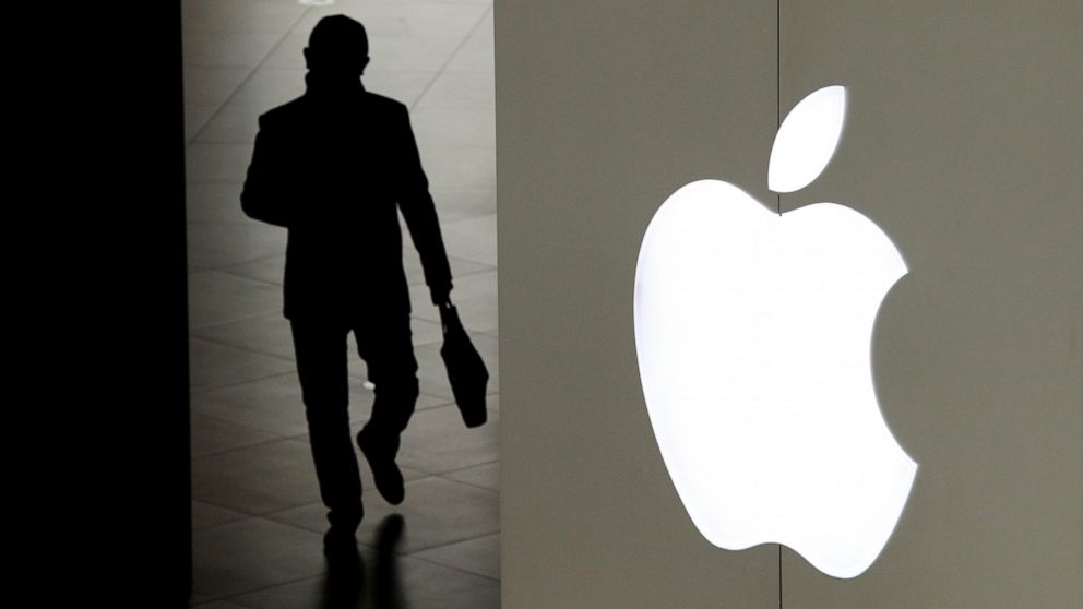 FILE- In this Jan. 3, 2019, file photo a man leaves an Apple store in Beijing. A trade court judge will recommend banning some iPhones from being imported into the U.S. after concluding Apple's best-selling device infringed on technology owned by mobile chip maker Qualcomm. The U.S. Trade International Trade Commission decision is the latest twist in a bitter legal dispute between Qualcomm and Apple over the rights to some of the technology that enables the iPhone to connect to the internet. (AP Photo/Andy Wong, File)