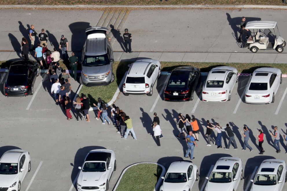 Students are evacuated by police out of Stoneman Douglas High School in Parkland, Fla., after a shooting on Feb. 14, 2018.