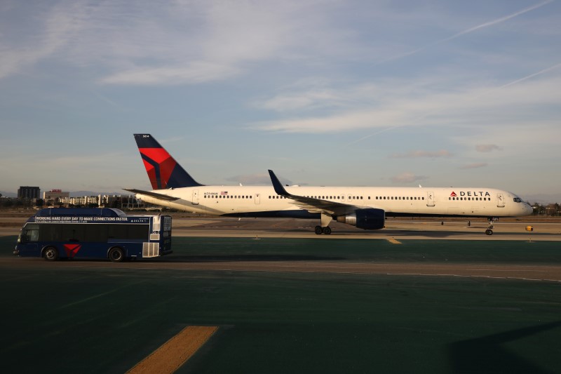 FILE PHOTO: A Delta plane passes a Delta bus on the tarmac at LAX airport in Los Angeles