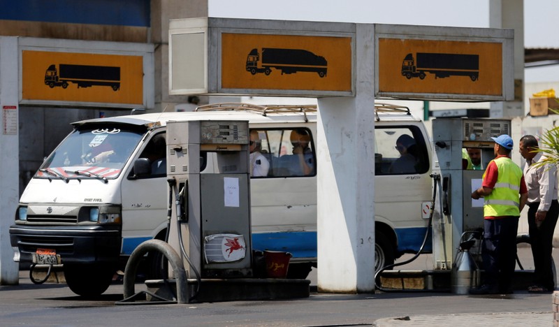 A microbus is filled up with fuel by an employe at a petrol station in Cairo