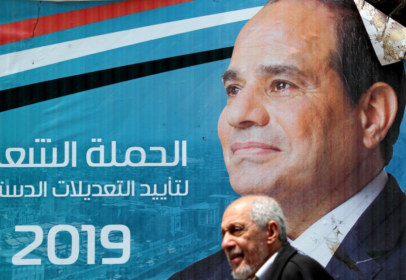 FILE PHOTO: A man walks in front of a banner depicting Egyptian President Abdel Fattah al-Sisi before the upcoming referendum on constitutional amendments in Cairo