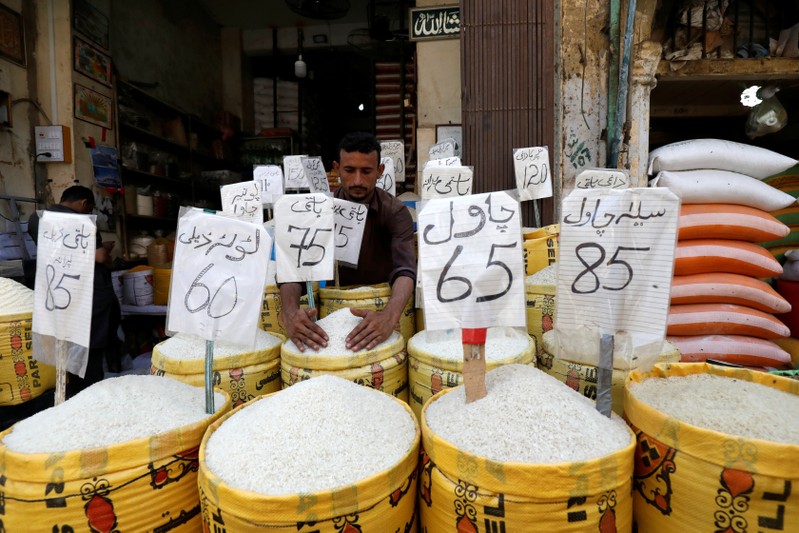 Vendor arranges different types of rice at his shop in a wholesale market in Karachi