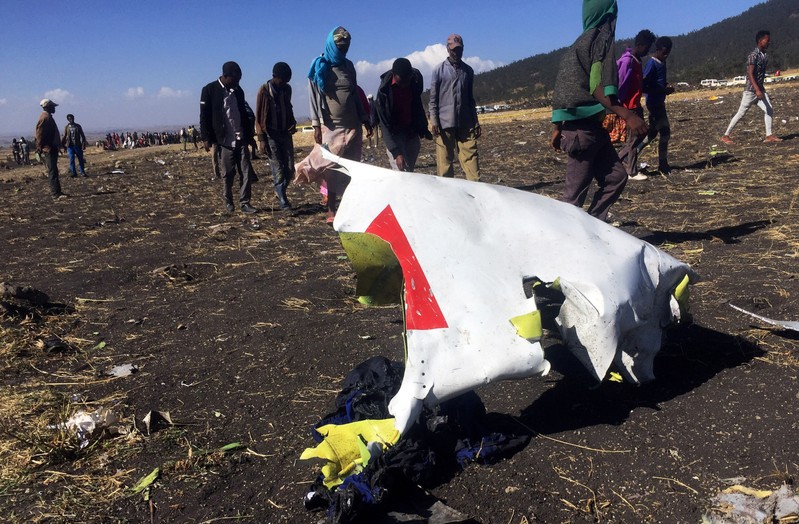FILE PHOTO: People walk past a part of the wreckage at the scene of the Ethiopian Airlines Flight ET 302 plane crash, near the town of Bishoftu, southeast of Addis Ababa