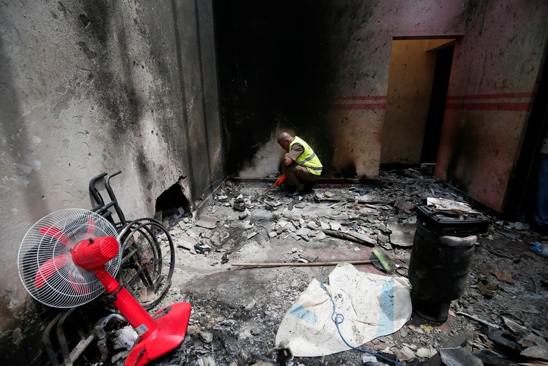 A police officer inspects the site of a gun battle between troops and suspected Islamist militants in Kalmunai