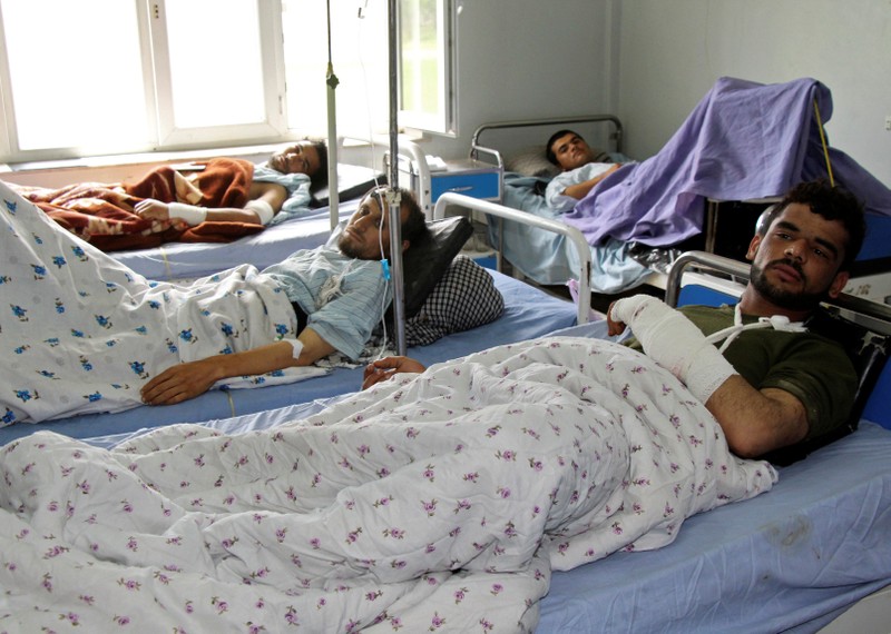 Wounded Afghan men receive treatment at a hospital one day after the start of the Taliban spring offensive, in Kunduz province