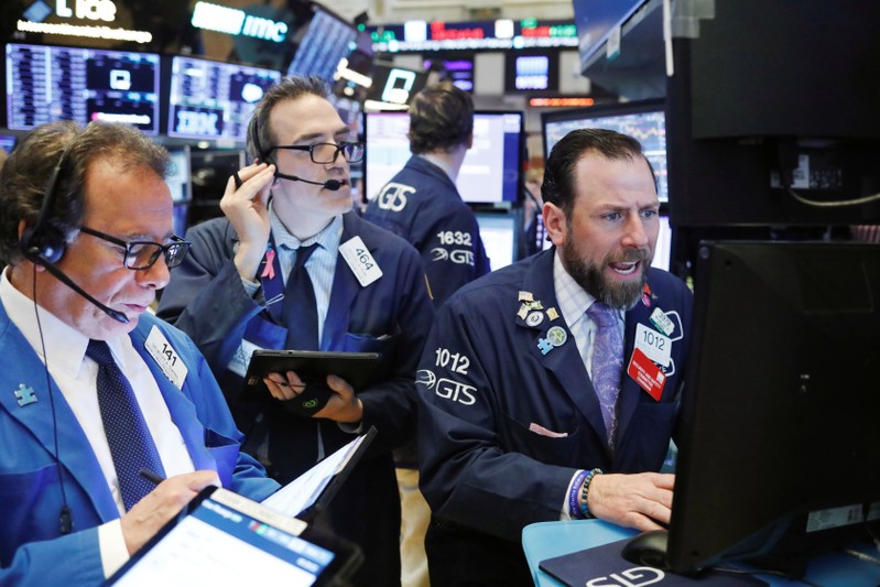 FILE PHOTO: Traders work on the floor of the New York Stock Exchange (NYSE) shortly after the opening bell in New York