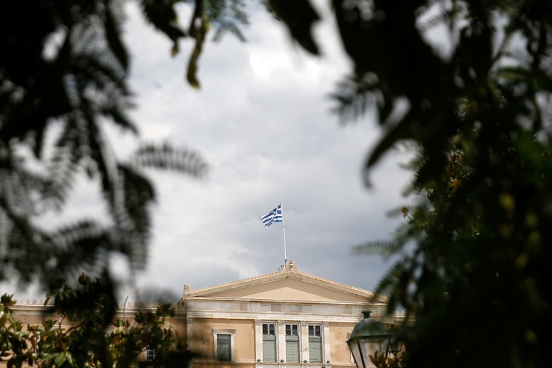 FILE PHOTO: A Greek flag flutters atop the parliament building in Athens