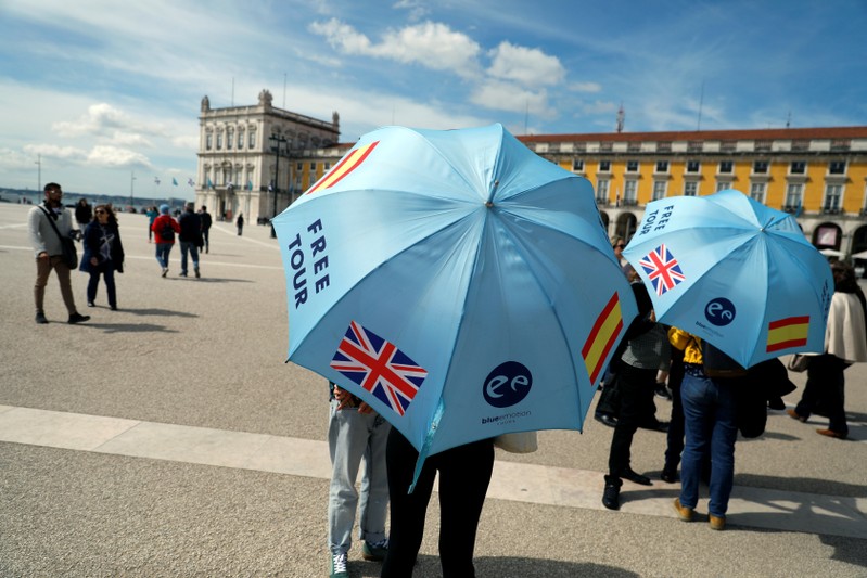 Tour guides wait for tourists at Comercio square in downtown Lisbon