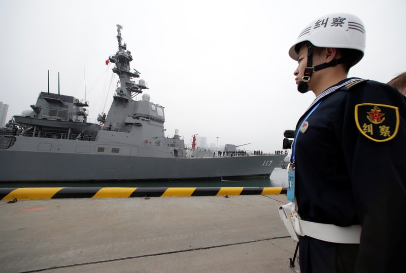 A Chinese navy personnel stands guard as the Japan Maritime Self-Defense Force destroyer JS Suzutsuki (DD 117) arrives at Qingdao Port for the 70th anniversary celebrations of the founding of the Chinese PLAN in Qingdao
