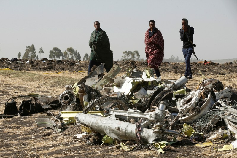 FILE PHOTO: Ethiopian police officers walk past the debris of the Ethiopian Airlines Flight ET 302 plane crash, near the town of Bishoftu, near Addis Ababa