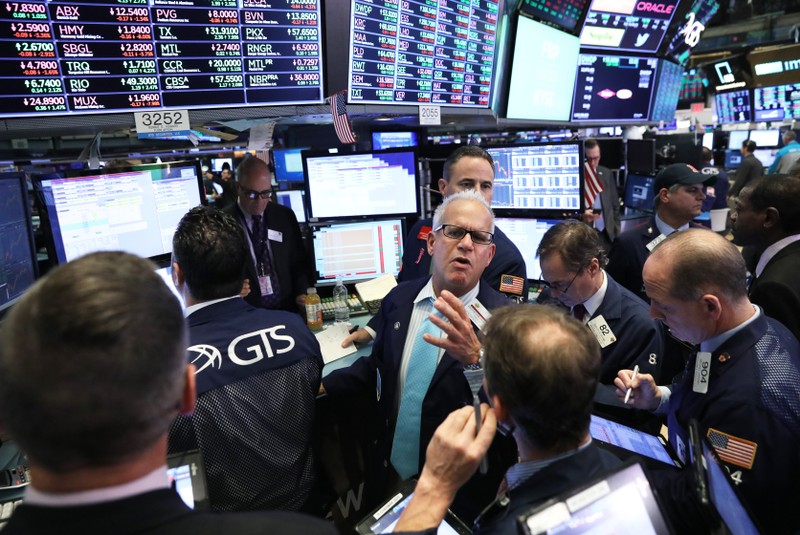 FILE PHOTO: Traders work on the floor of the New York Stock Exchange (NYSE) near the close of market in New York