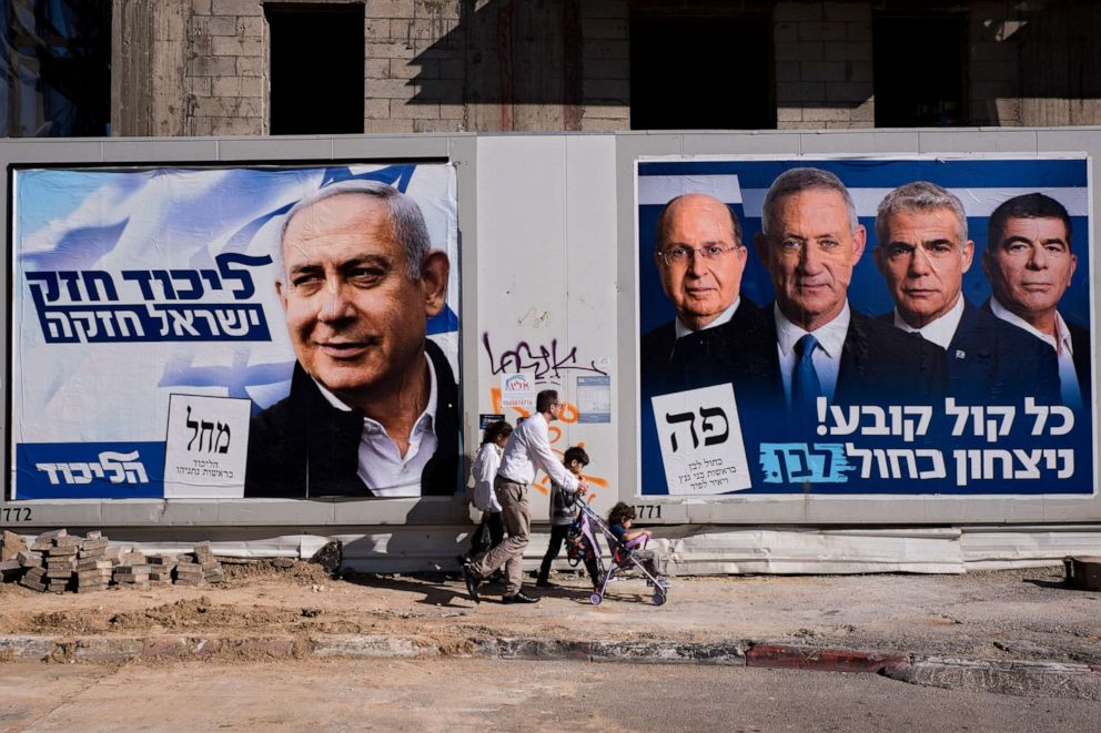 People walk by election campaign billboards in Tel Aviv, Israel, April 3, 2019.