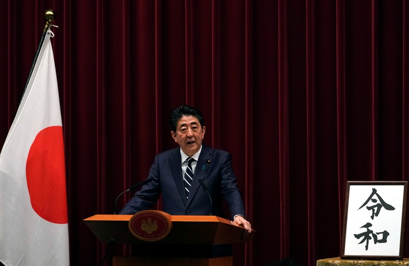 FILE PHOTO: Japan's Prime Minister Shinzo Abe delivers a press conference standing next to the calligraphy 'Reiwa' which was chosen as the new era name at the prime minister's office in Tokyo