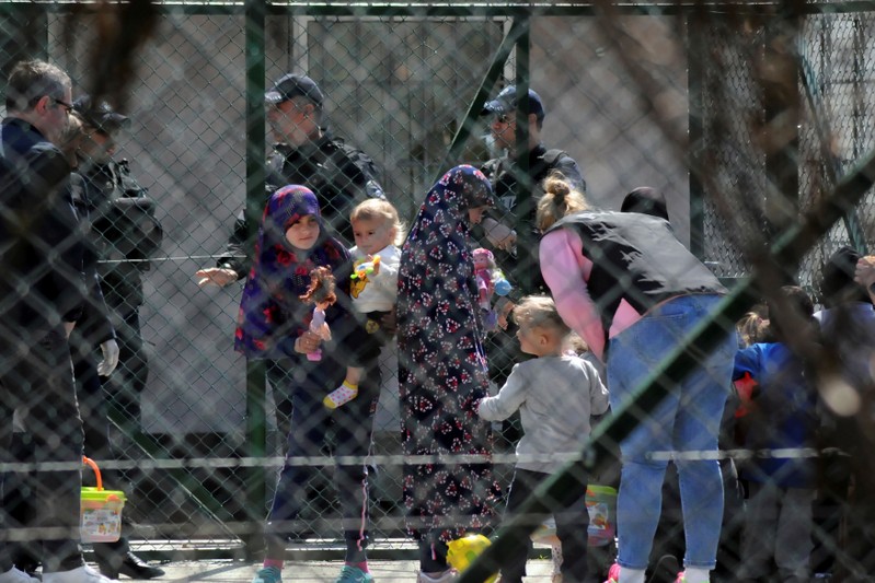 Police officers guard women and children who are relatives of Kosovo Jihadists who returned from Syria, at foreigners detention centre in Pristina