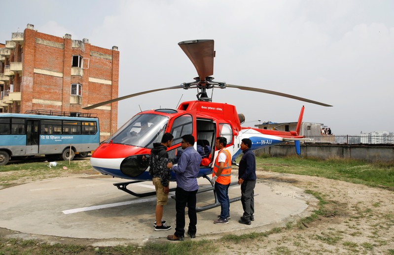 A helicopter carrying the bodies of the victims of a small aircraft belonging to Summit Air, that crashed with a helicopter parked at Lukla airport, waits to get transported for postmortem examination at a hospital in Kathmandu