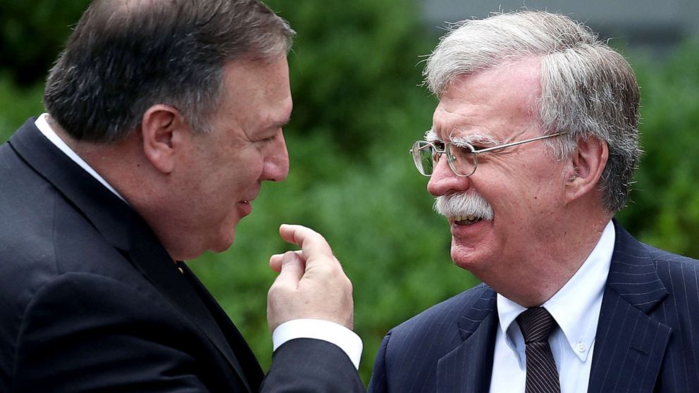 Secretary of State Mike Pompeo (left) talks with White House National Security Advisor John Bolton before a news conference with President Donald Trump and Japanese Prime Minister Shinzo Abe, in the Rose Garden at the White House, on June 7, 2018, in Washington, D.C.