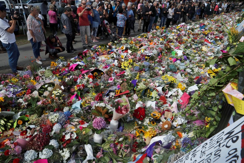 People visit a memorial site for victims of Friday's shooting, in front of Christchurch Botanic Gardens in Christchurch